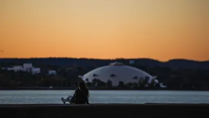 学生坐在防波堤上，俯瞰纽大的苏必利尔圆顶.