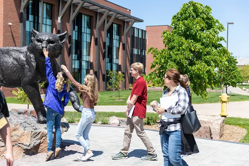 一群未来的买球app学生在Jamrich Hall外的买球app野猫雕像前.